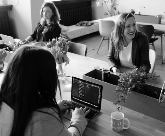 Girls analyzing business data on laptops